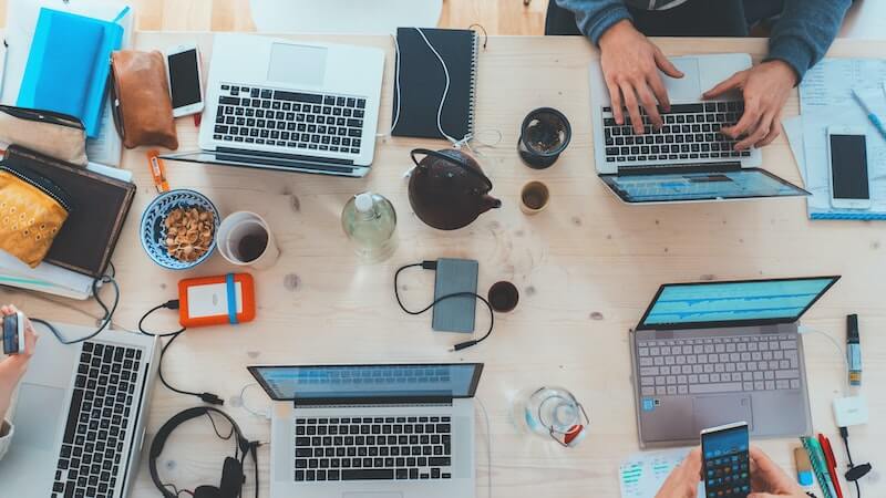 People working on laptops around a table